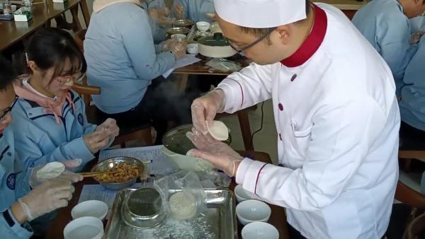 英语老师将课堂搬到食堂，让学生边包饺子边学英语
