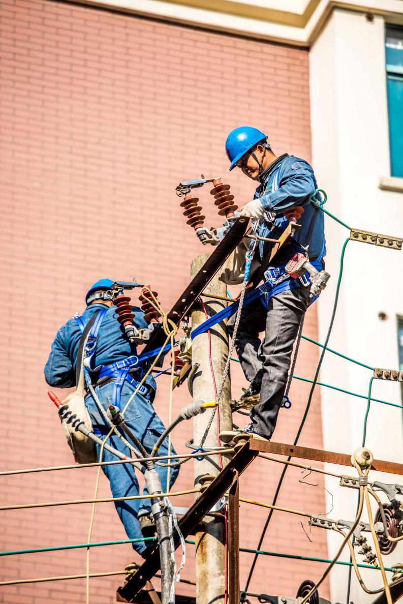 图为国网庐江县供电公司员工在福安小区安装线路避雷器
