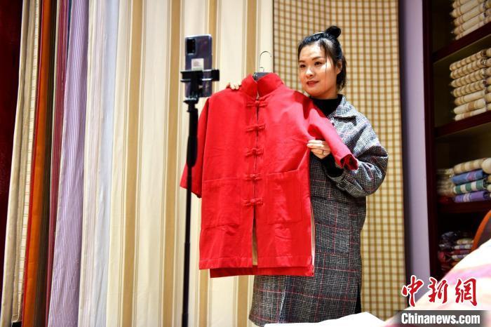 工作人员在河北省衡水市冀州区田园棉文化园销售展区对粗布家居产品进行现场直播。 辛培 摄