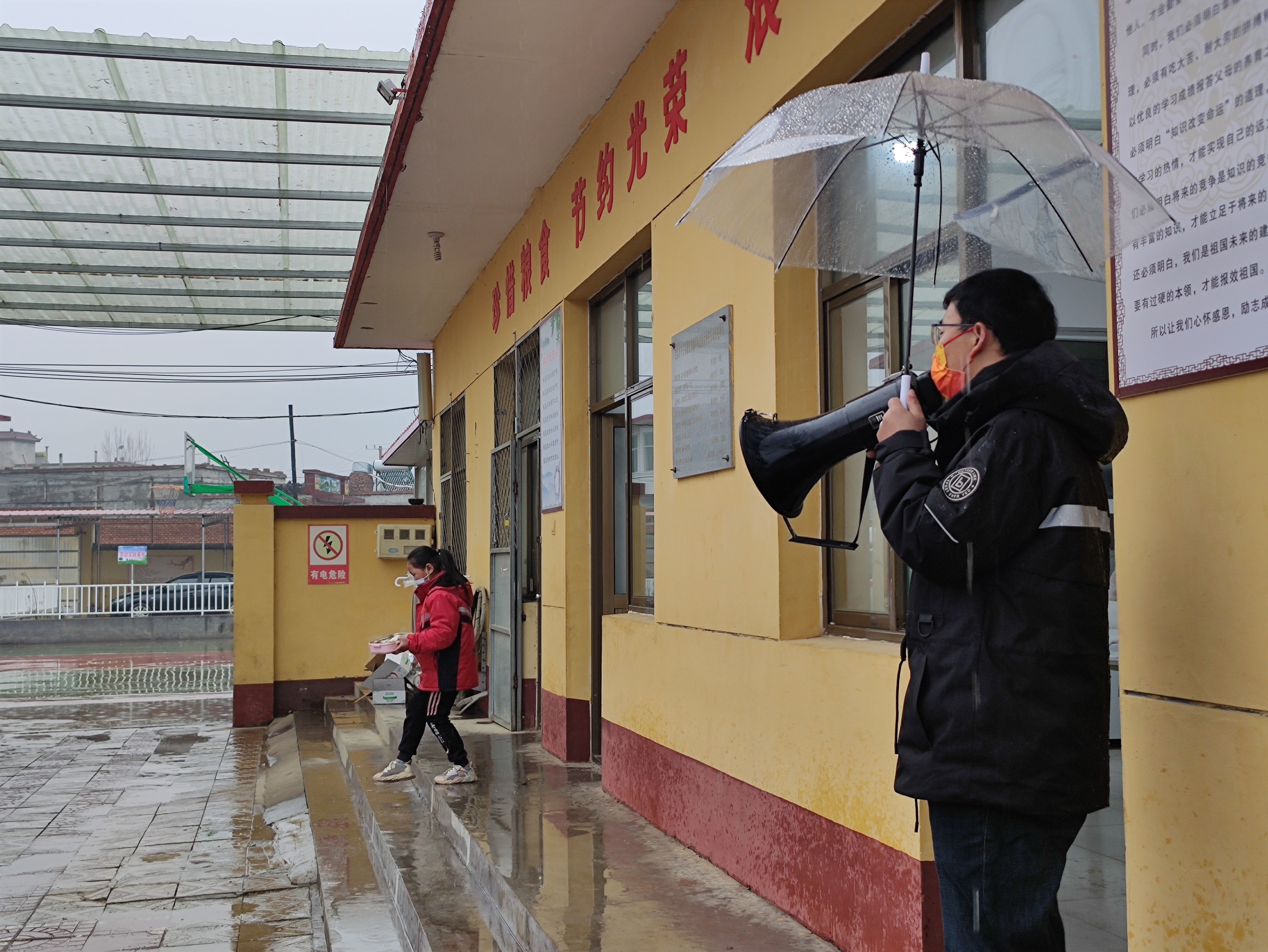 11月29日，陈文水撑伞指挥孩子打饭。新京报记者 郭懿萌 摄