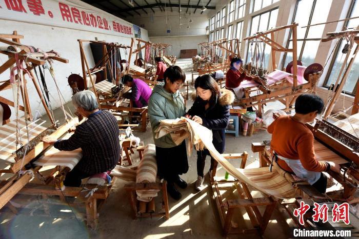 田园棉手织布传承人在河北省衡水市冀州区田园棉文化园织布车间检查粗布品质。 辛培 摄