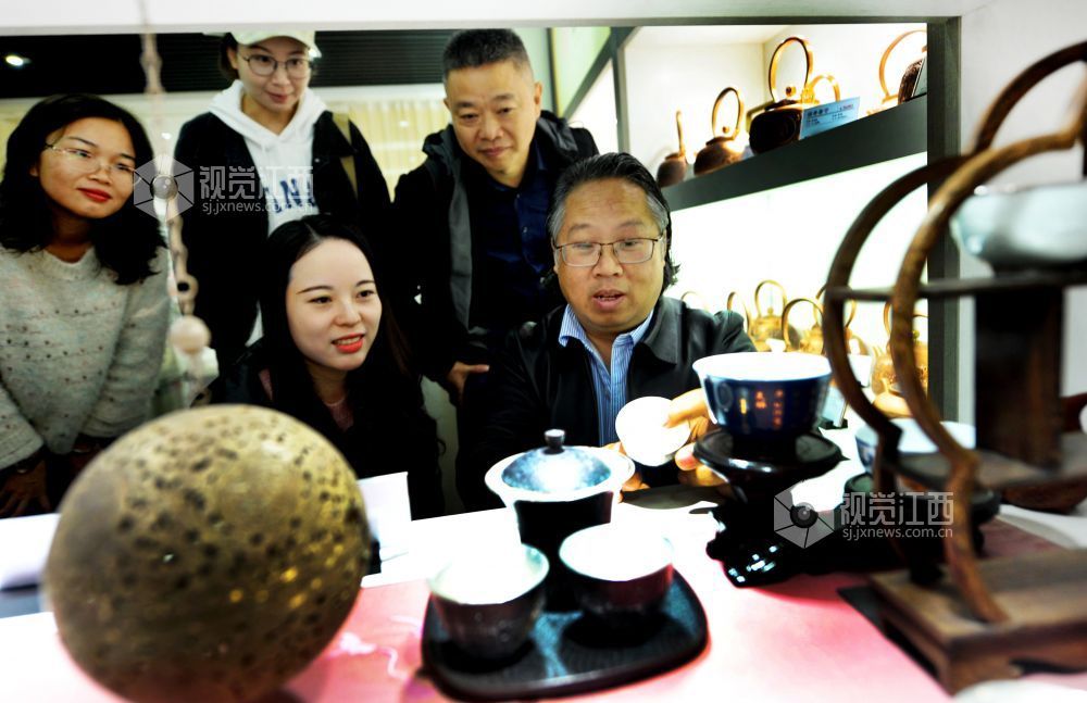 2021年12月17日，江西省贵溪市国家级技能大师、錾铜雕刻“非遗”传承人黄俊军正在给顾客讲解錾铜雕刻作品。