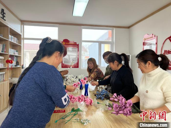 农闲时节,迁西县农村妇女聚集在农家书屋学习插花艺术。
