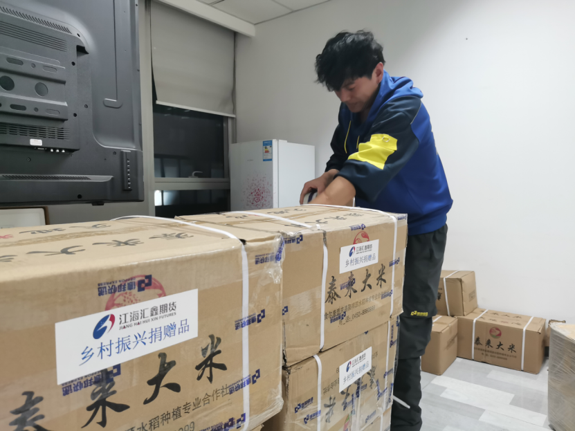 快递员在江海汇鑫期货库房打包邮寄大米.