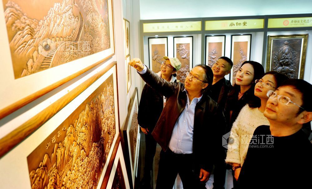 2021年12月17日，江西省贵溪市国家级技能大师、錾铜雕刻“非遗”传承人黄俊军正在给顾客讲解錾铜雕刻作品。