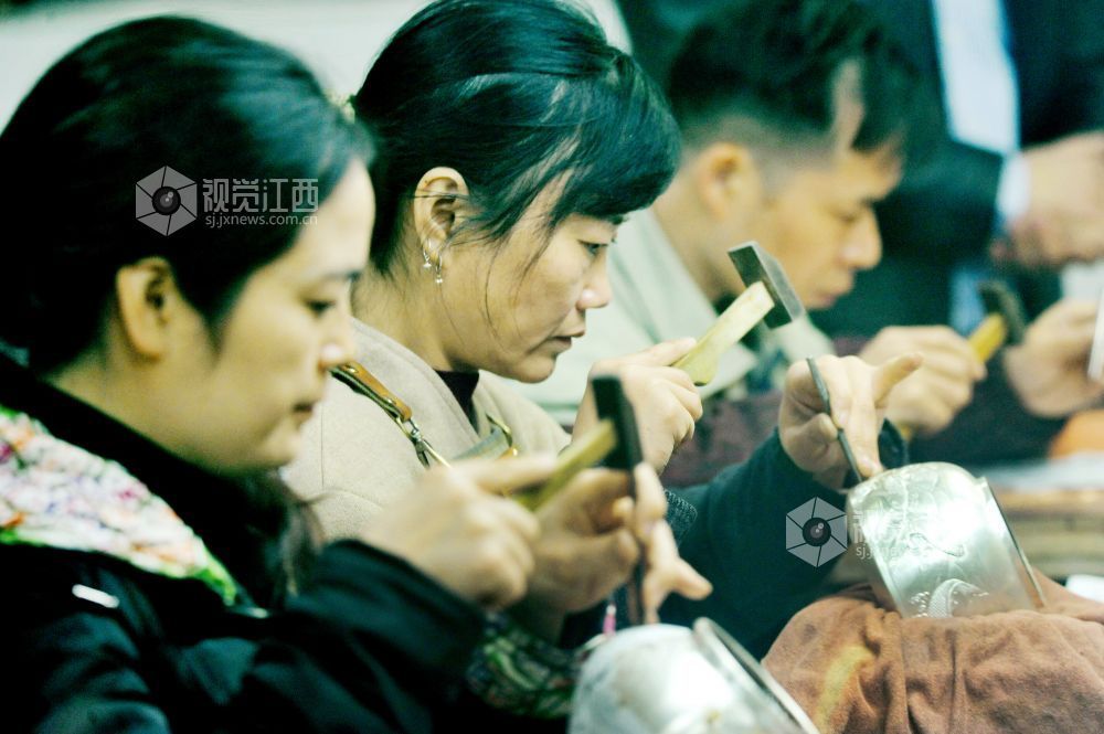 2021年12月17日，江西省贵溪市国家级技能大师、錾铜雕刻“非遗”传承人黄俊军的“弟子”们正在精心创作錾雕作品。