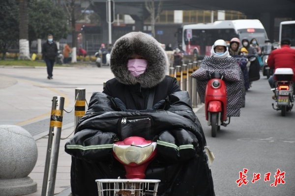 骑车和步行赶着上班的市民穿着厚厚的冬装把自己裹得严严实实抵御寒冷