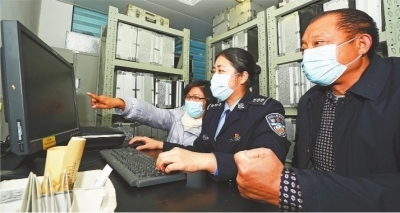 民警黄雯为陈真响（右）和吴学先（左）调取采血信息。 通讯员孙逊 摄