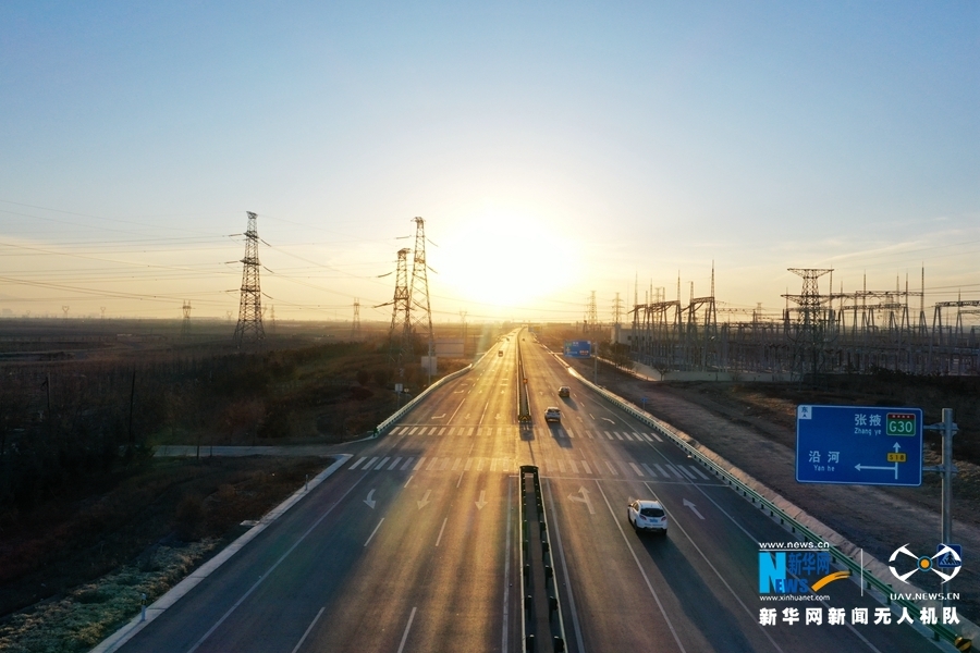 这是2021年12月31日航拍的朝阳下的s18张掖至肃南一级公路部分路段