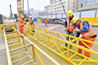 1月4日，武汉地铁12号线十五中站，施工人员正在吊装大型履带吊车的吊臂。长江日报记者李永刚 摄