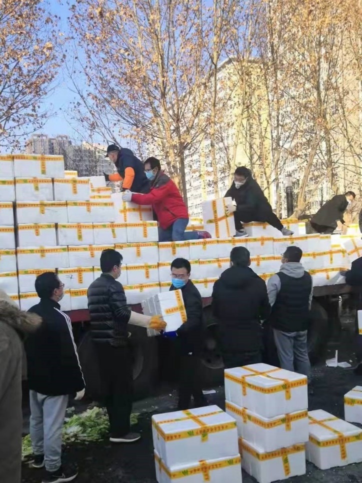 许奎香夫妇协助社区人员搬运爱心蔬菜