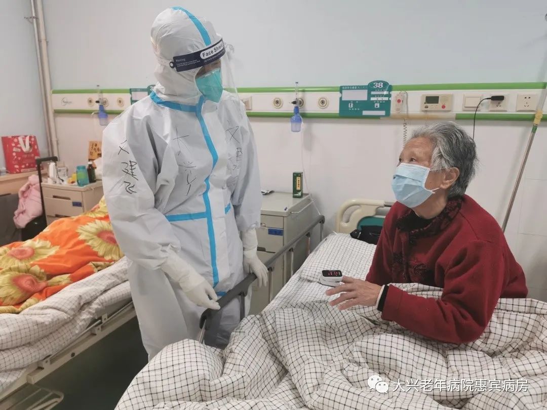 图为文建飞医生在新冠患者定点收住医院查房照片