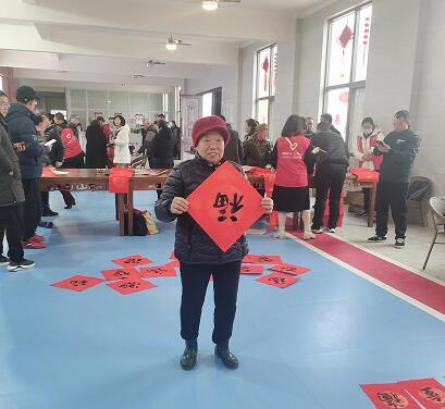 村民拿到写好的“福”，正在展示