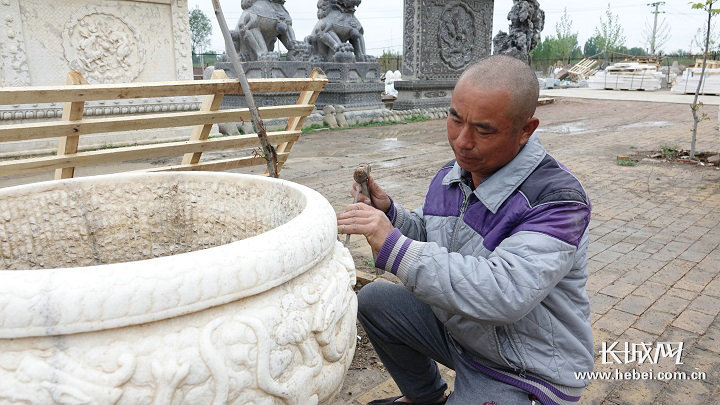 张岗三村的手艺师傅李喜良正在打磨仿古石雕。记者 王棋 摄