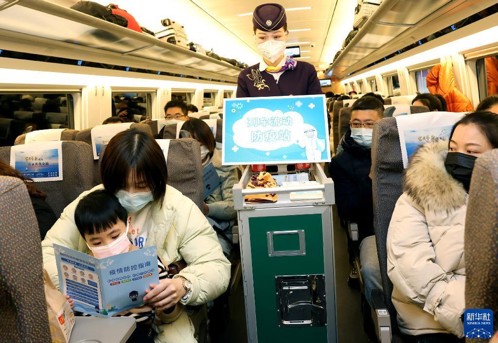 1月16日,乘务员在上海虹桥开往汉口的g1724次列车上向旅客分发防疫