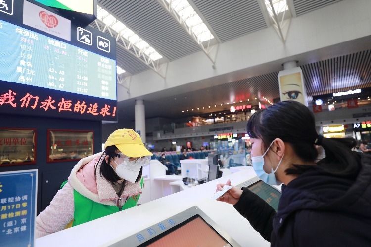 南昌车站青年志愿者正在帮助旅客查询信息。（张杰 摄）