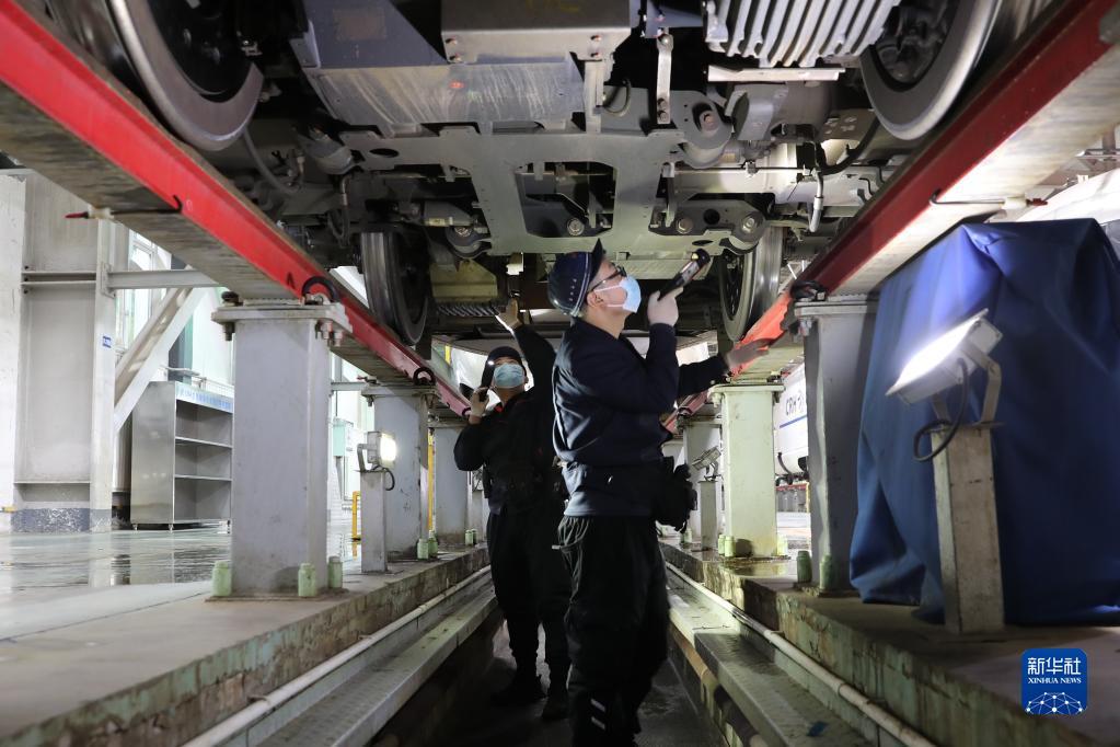 1月16日，在中铁兰州局兰州车辆段兰州西动车运用所整备场，工作人员检修维护动车组列车。新华社记者 杜哲宇 摄