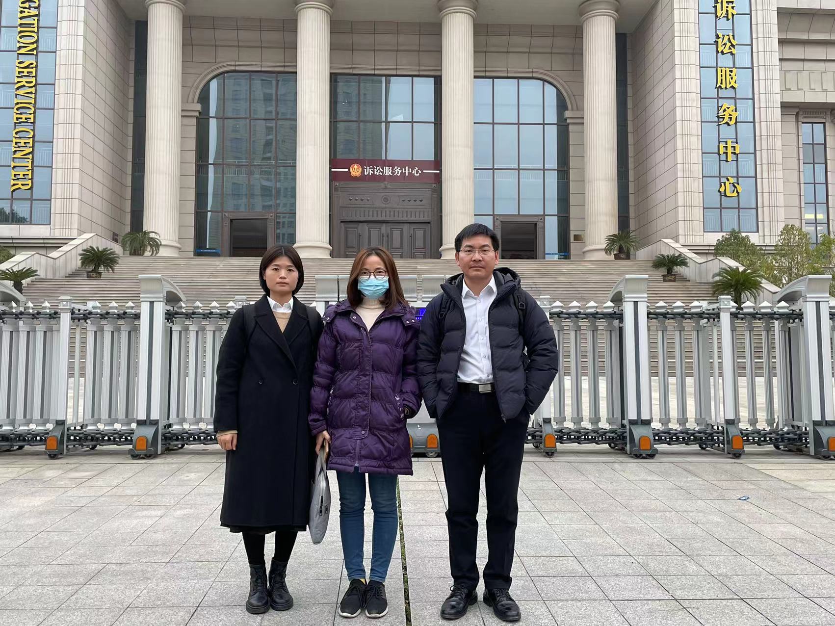 1月18日，汪珍珍（左）和代理律师王飞、张晓丽在江西高院门前合影。受访者供图