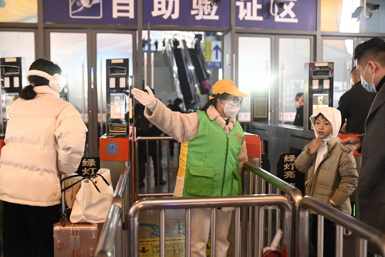 南昌车站青年志愿者正在引导旅客进站方向。（周雨欣 摄）