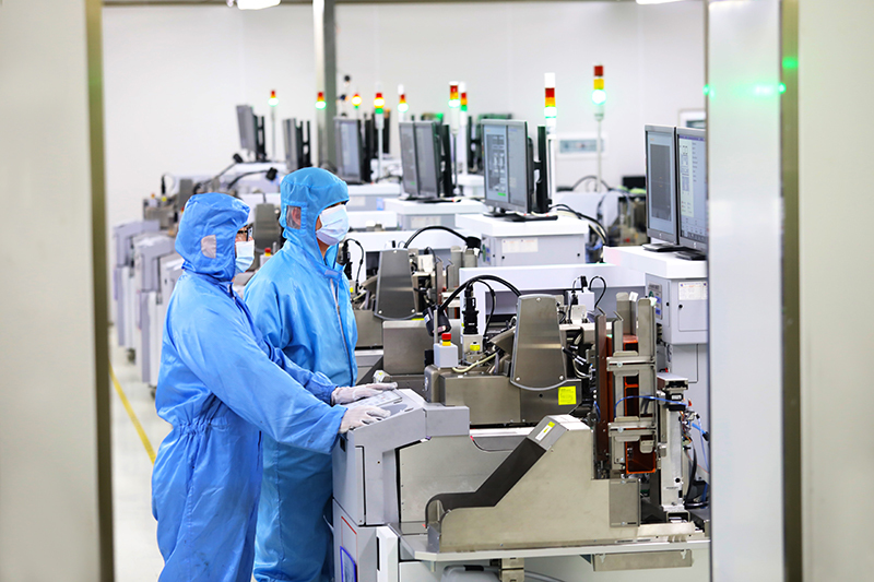 重庆平伟实业股份有限公司无尘生产车间，工人在通过电子显示屏观察电子芯片的生产情况。刘辉 摄