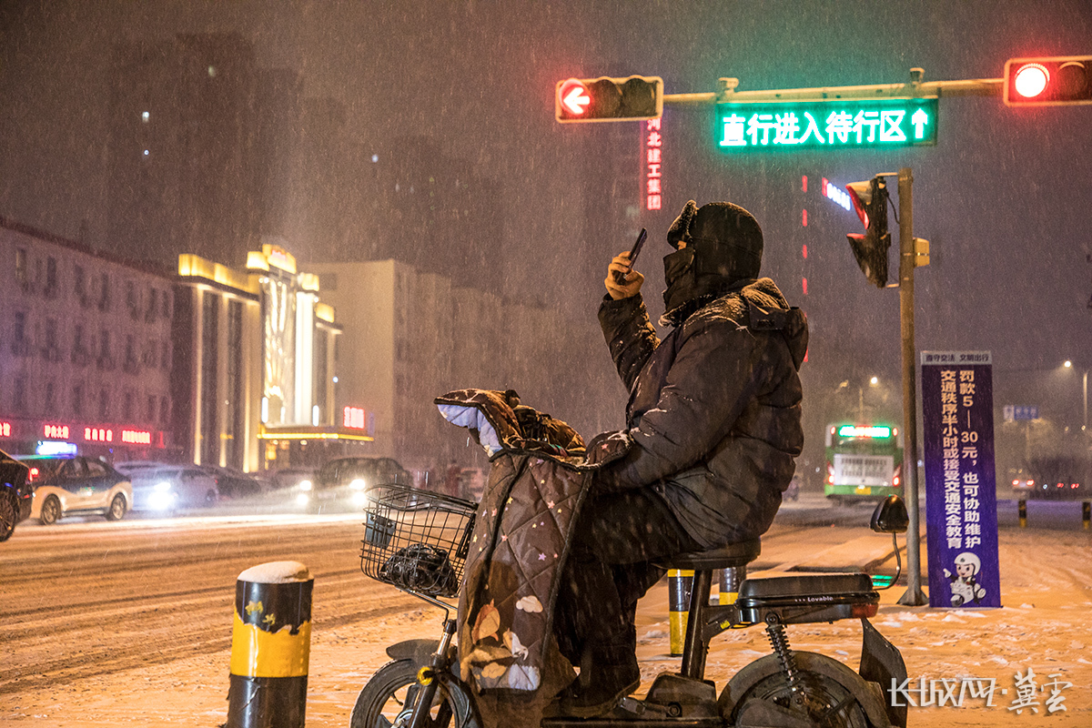 市民举起手机在路边拍摄雪景。长城网·冀云客户端记者 李皓 摄