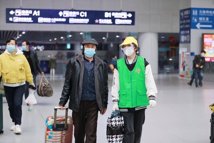 南昌车站青年志愿者正在帮助老年旅客。（张杰 摄）