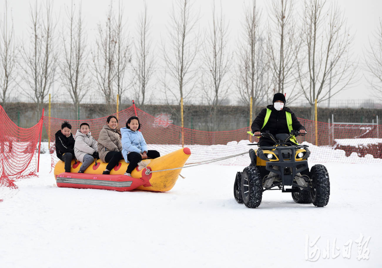 2022年1月26日,游客在河北省邢台市南和区贾宋镇嘉年华滑雪场坐雪上