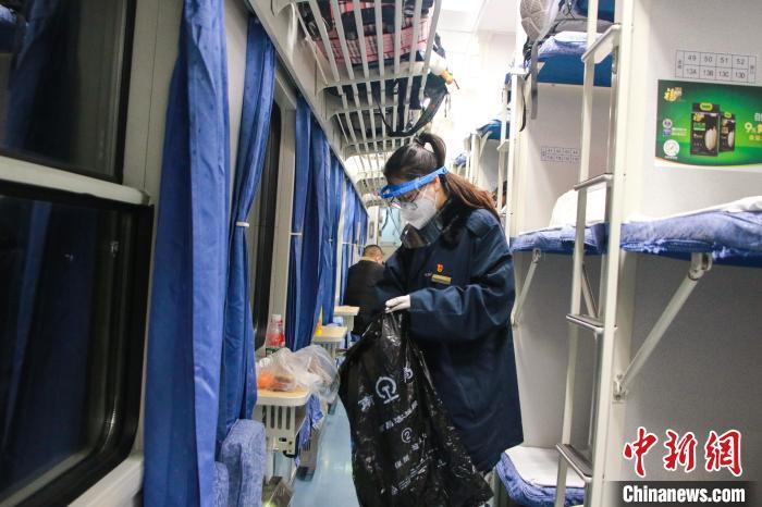 图为王心月在临客列车上清理垃圾。　郭延民 摄