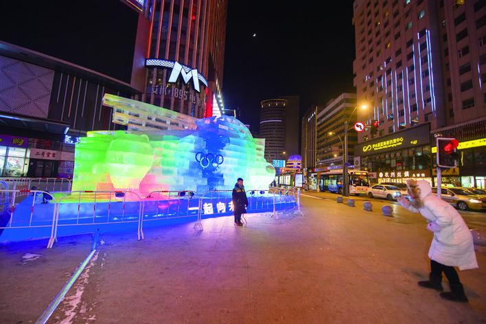 24日，在西安大路与同志街交会处，行人与大型冰雕“一起向未来”合影留念。 张扬 摄