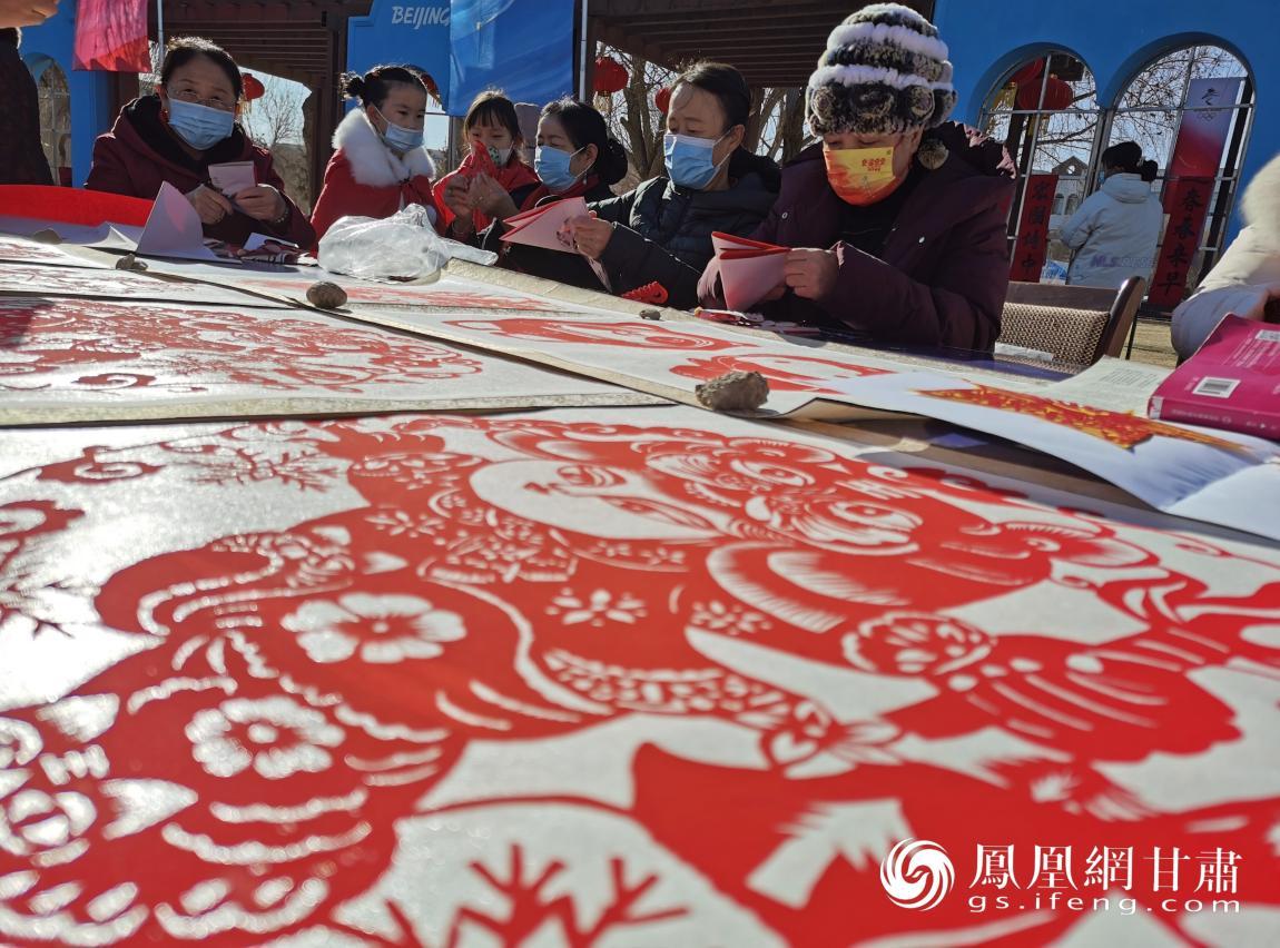 广场上举办写春联，剪窗花活动，年味儿与冬奥氛围互相衬托，相得益彰。闫琴雯 摄