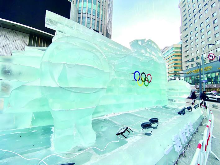 24日，在西安大路与同志街交会处，以北京冬奥为主题的大型冰雕“一起向未来”呈现在街头。“冰墩墩”和“雪容融”与奥运五环格外显眼。 赵滨 摄