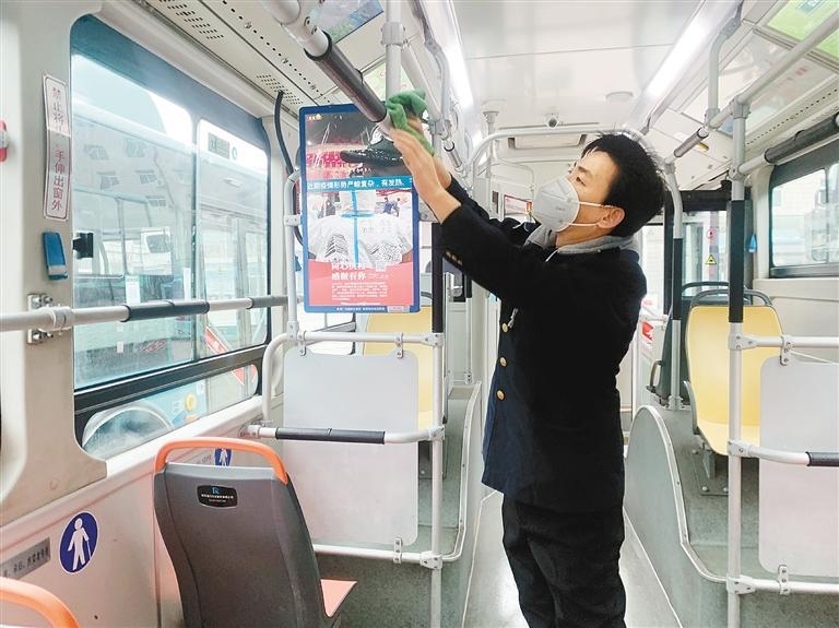 公交车驾驶员弋晓东正在擦拭车把手。