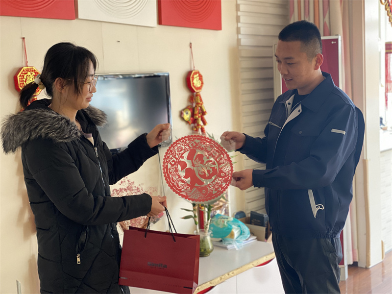 1月31日，在三河同飞制冷股份有限公司员工为不返乡人员送窗花和慰问品。 通讯员高澍摄