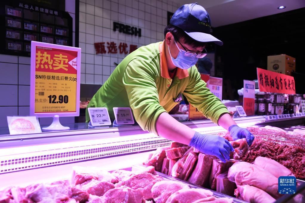 在北京市海淀区一家超市，工作人员码放鲜肉（2021年12月31日摄）。任超 摄