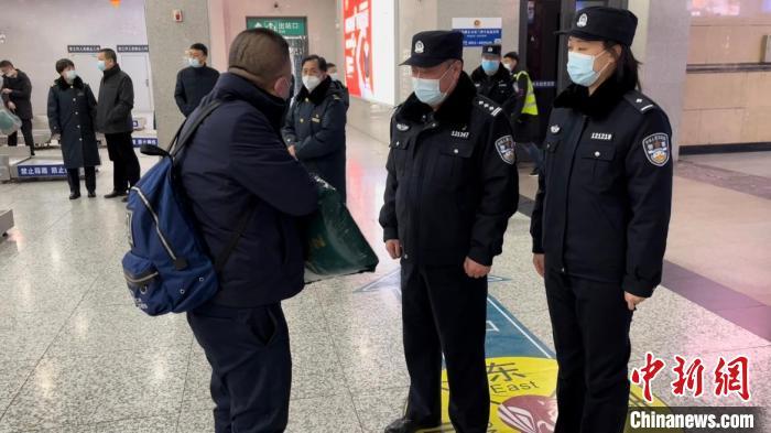 石跃广正在检查来往旅客有无鞋带违禁物品进站，同时向新同事高艺卿演示如何进行工作。