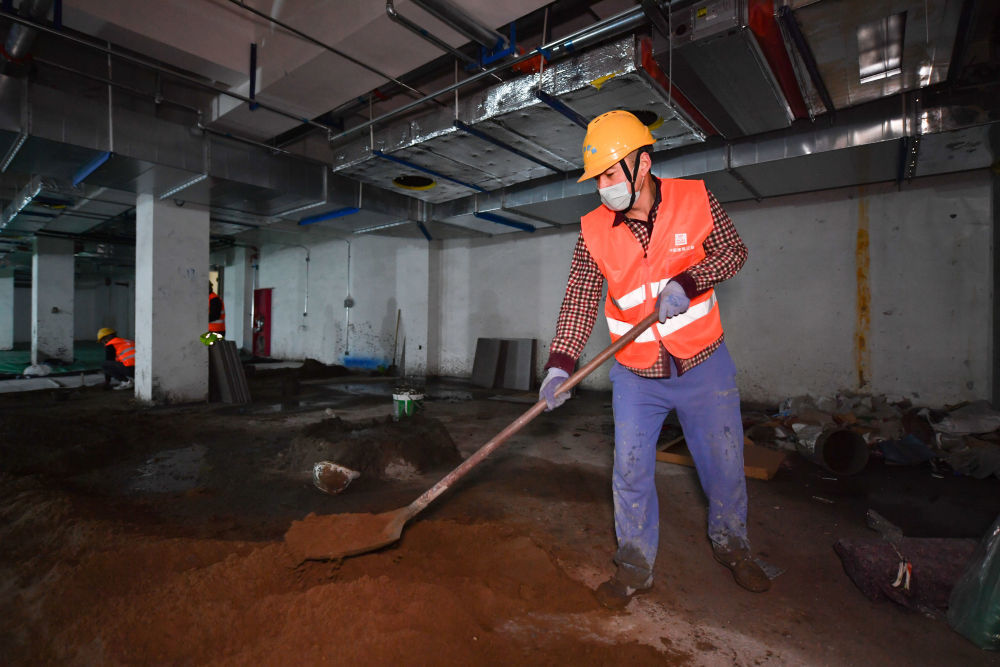 在西安市第一实验学校建设项目工地,留守工地的工人在施工现场工作