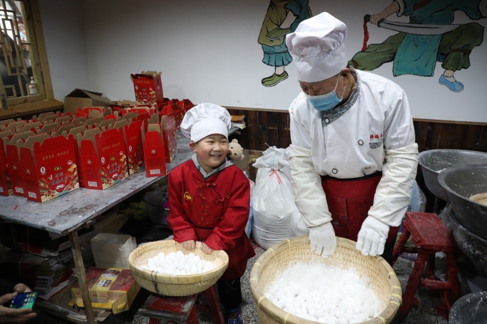 图为韩福元和孙子一起滚元宵