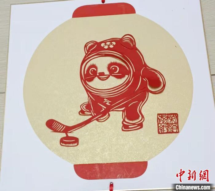 来自甘肃省庆阳市的剪纸传承人张荣娟,凭借巧手剪出了姿态各异的冬奥会吉祥物“冰墩墩”。 徐雪 摄
