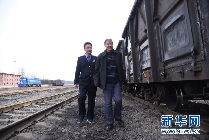 史小峰（左一）和史国瑞（右一）在铁路轨道旁查看车辆 新华社记者 崔翰超 摄