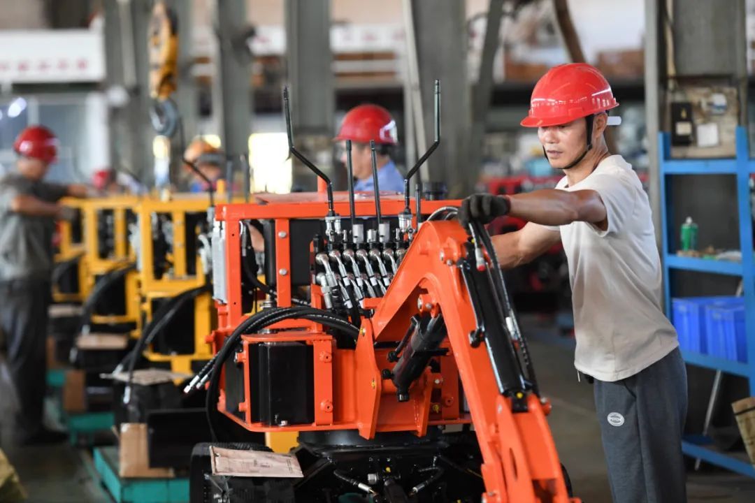 高安市南特東騰工程機械製造有限公司的工人在組裝挖掘機.