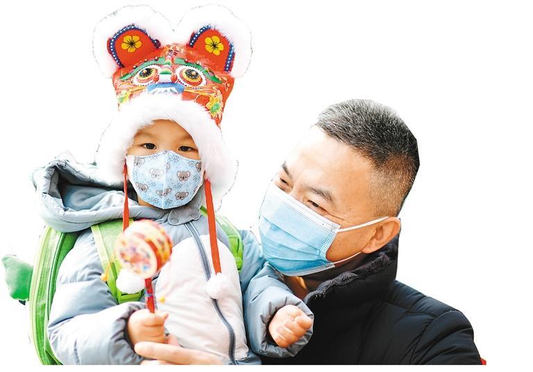 二月十五日，戴着虎头帽的小朋友和家人在西安永兴坊游览。　　（新华社发 熊世钰 摄）