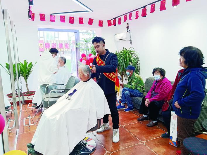 杜鹏为老人免费理发。 康重华 摄