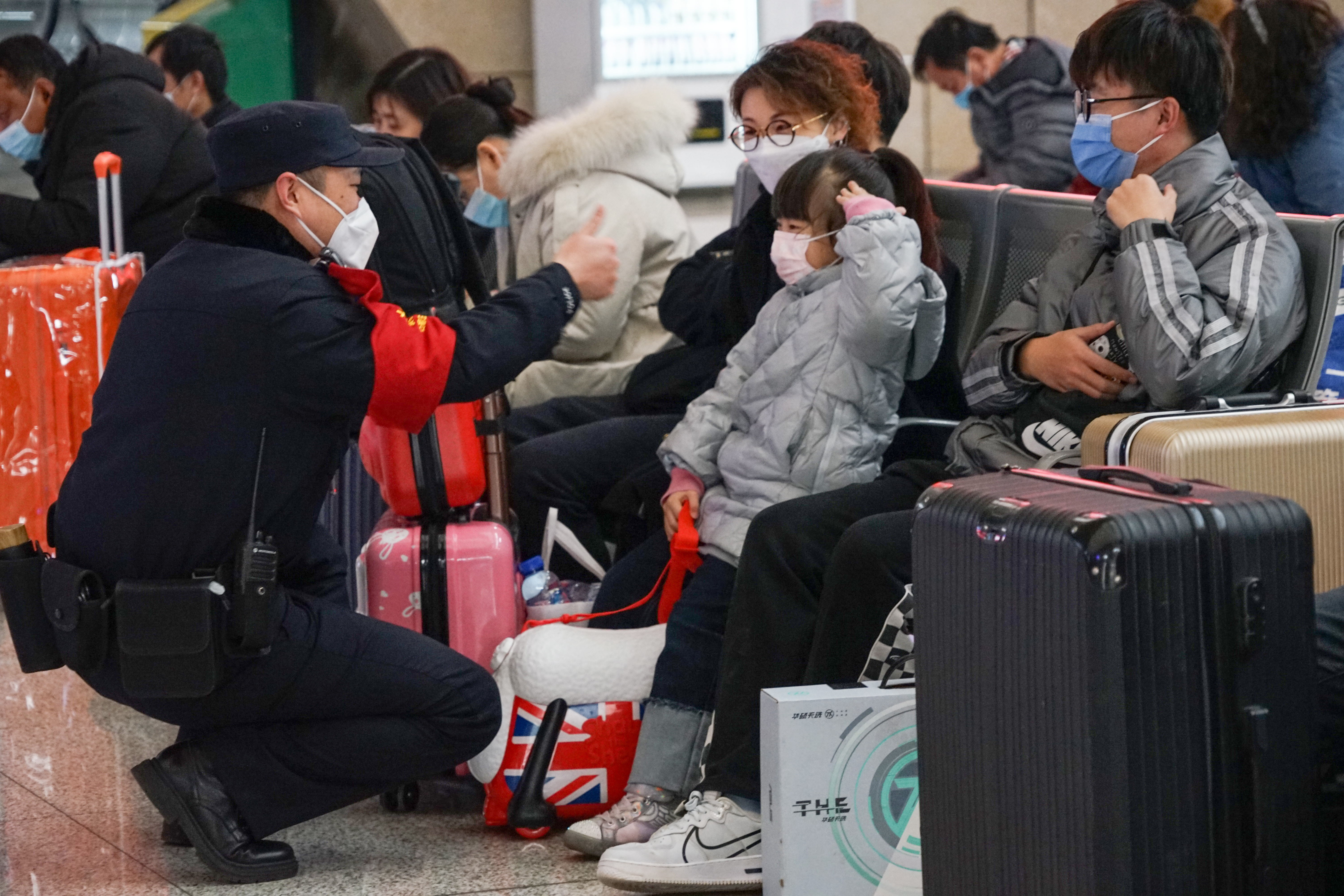 2022年2月,梁泽云在候车室提醒小朋友带好口罩.