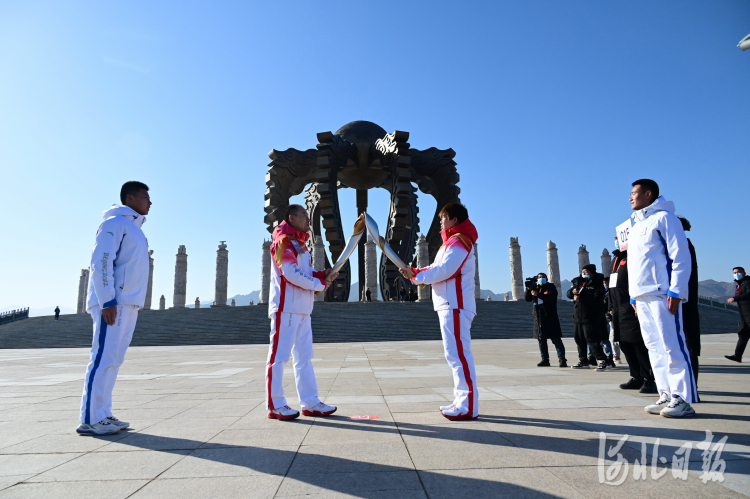 2022年3月2日上午，张家口赛区与北京赛区、延庆赛区同步启动北京冬残奥会火种采集仪式。图为涿鹿黄帝城“文明之火”采集仪式现场，火炬手张文（左）正在与火炬手米娜（右）进行火炬交接。河北日报记者田明摄影报道