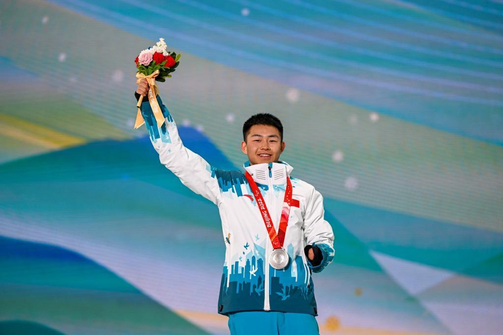 中国选手蔡佳云在越野滑雪男子长距离传统技术(站姿)比赛颁奖仪式上