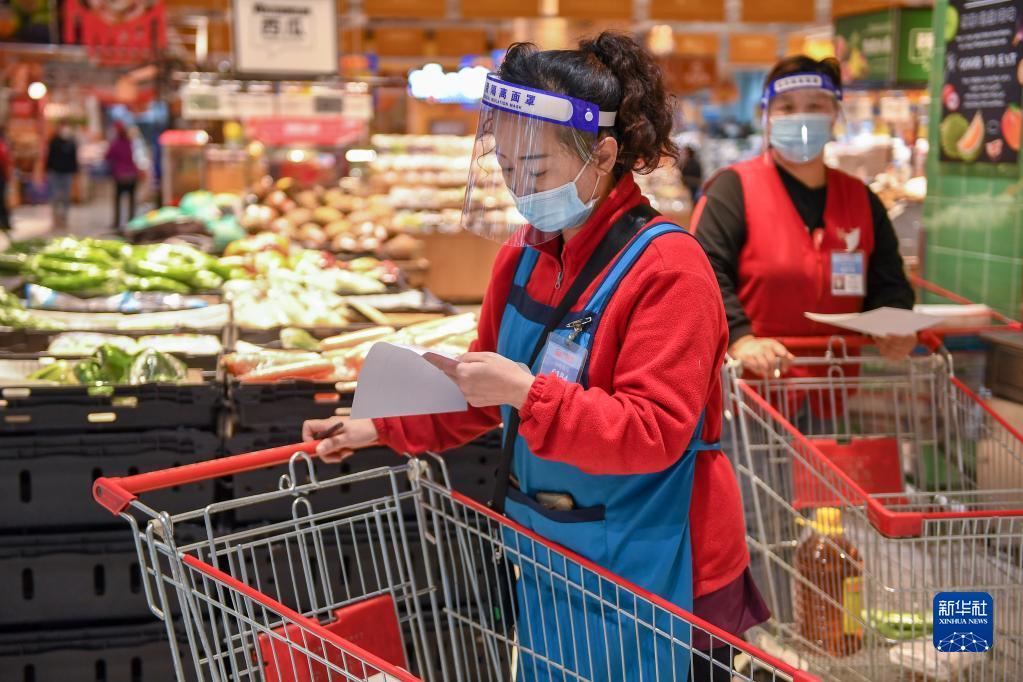 3月16日,在吉林市大润发超市,工作人员核对居民线上订单.