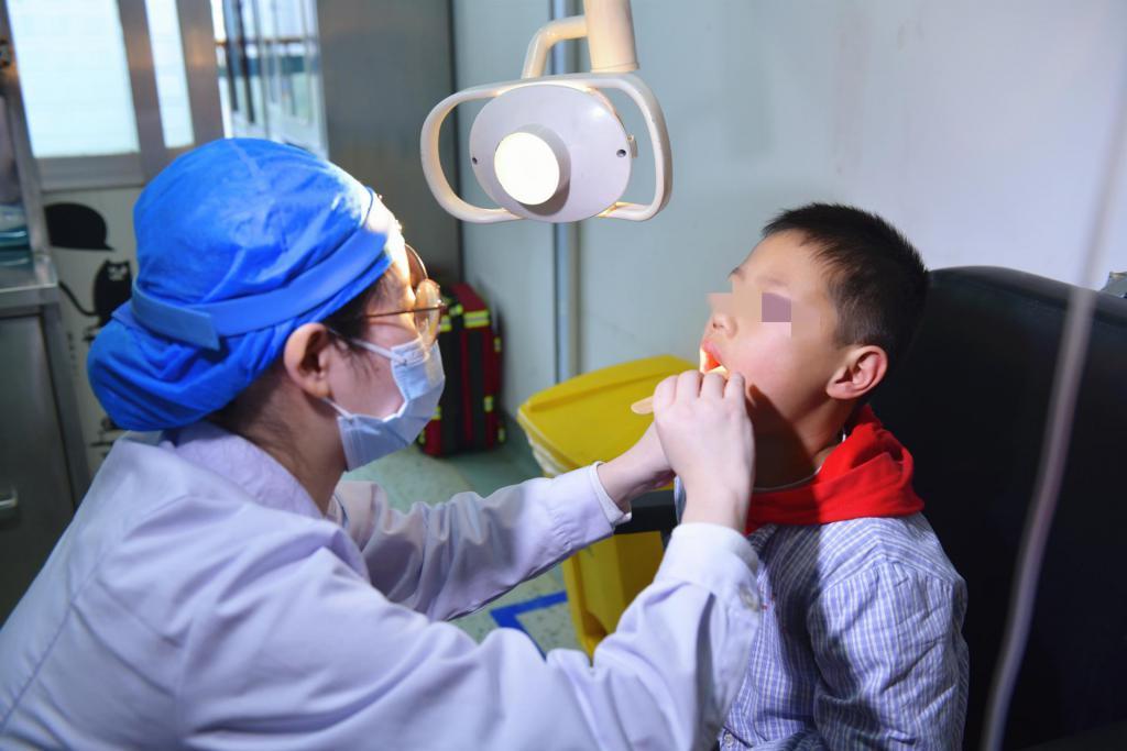 湖南省儿童医院耳鼻咽喉头颈外科医师谢丽华为星星进行术前检查