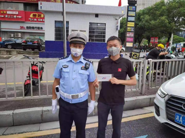 民警为斑马线前主动礼让的驾驶人送上“小礼品”。