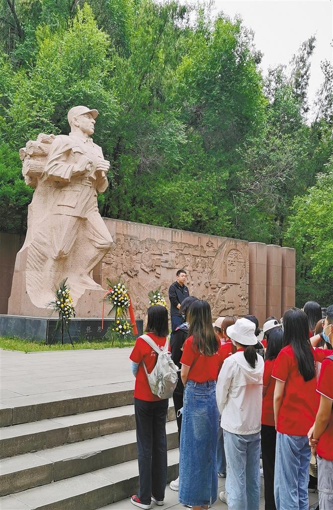 陕西师范大学思政课教师在张思德塑像前向学生们讲授革命先辈的英雄