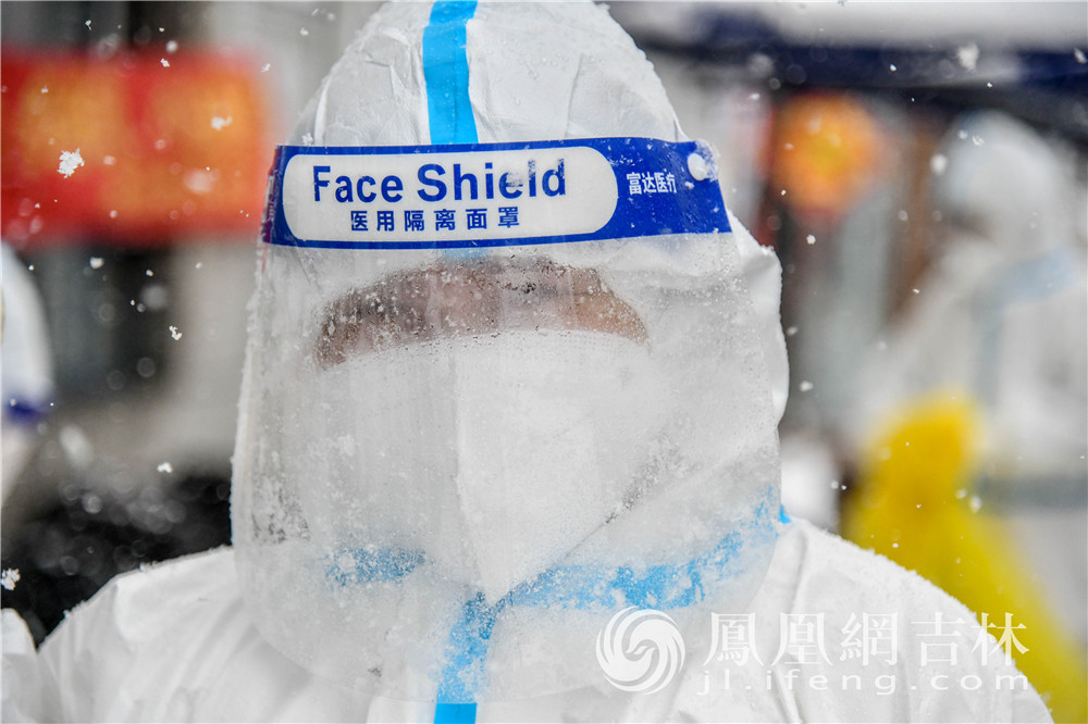 在雪中，核酸检测工作人员面罩上形成水珠。凤凰网吉林 梁琪佳摄